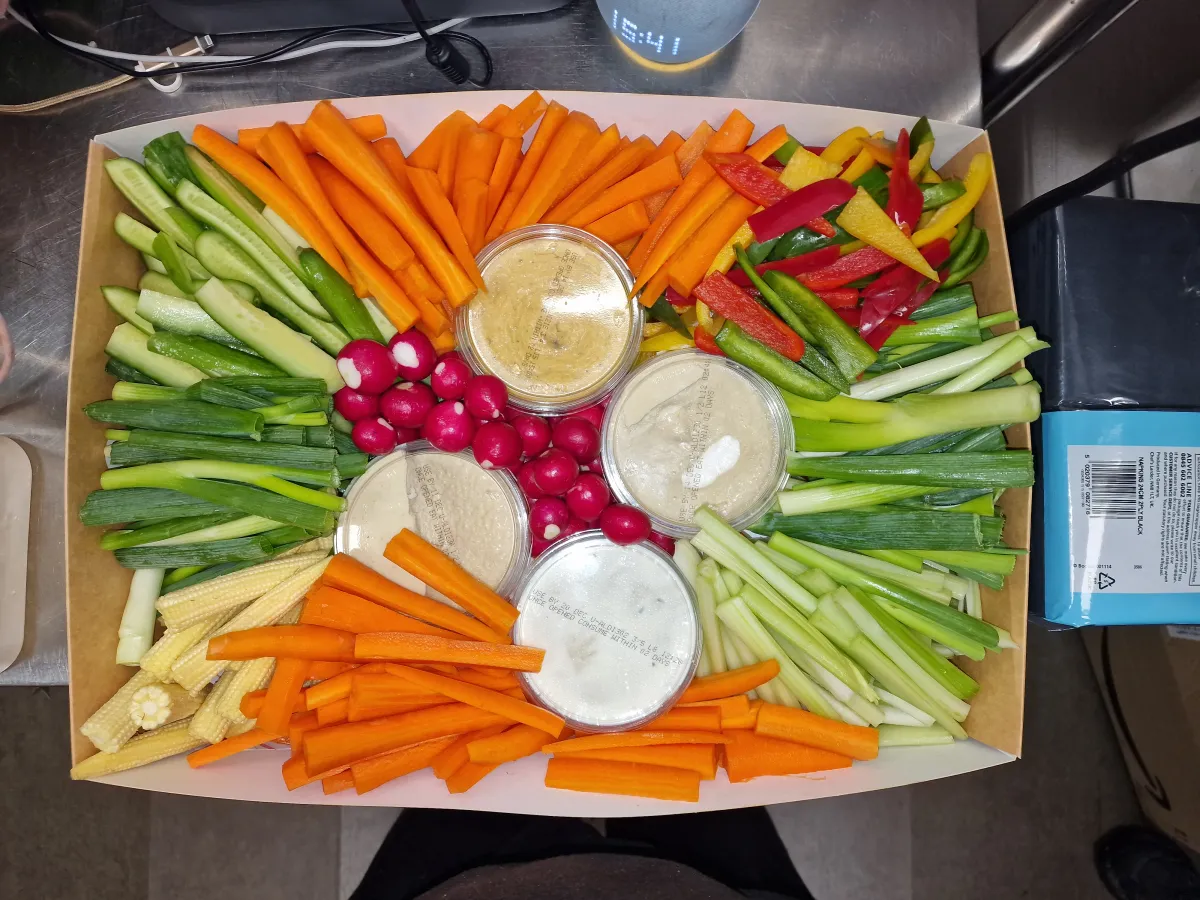Wide crudités platter with hummus, celery, carrots and radishes