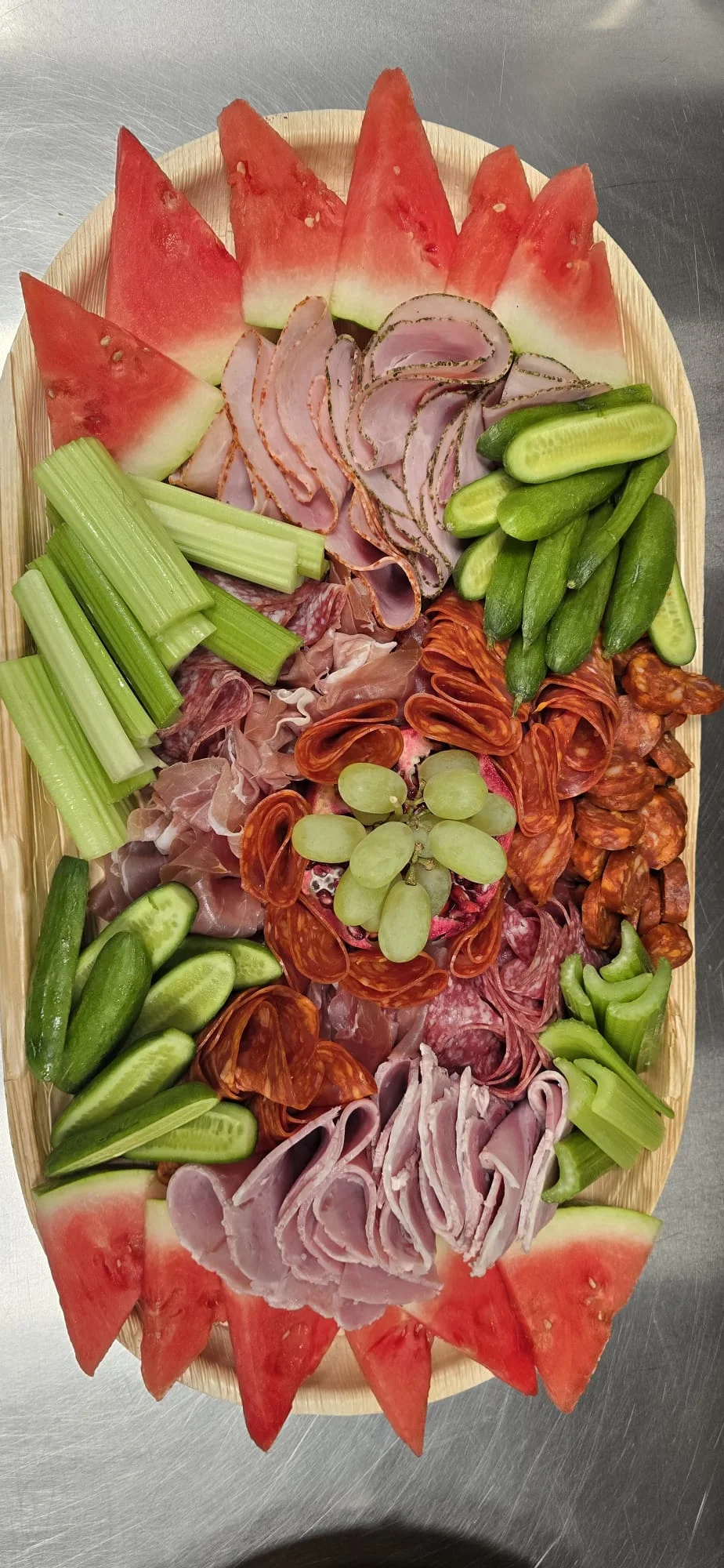Overhead charcuterie and grazing board with meats, olives and grapes