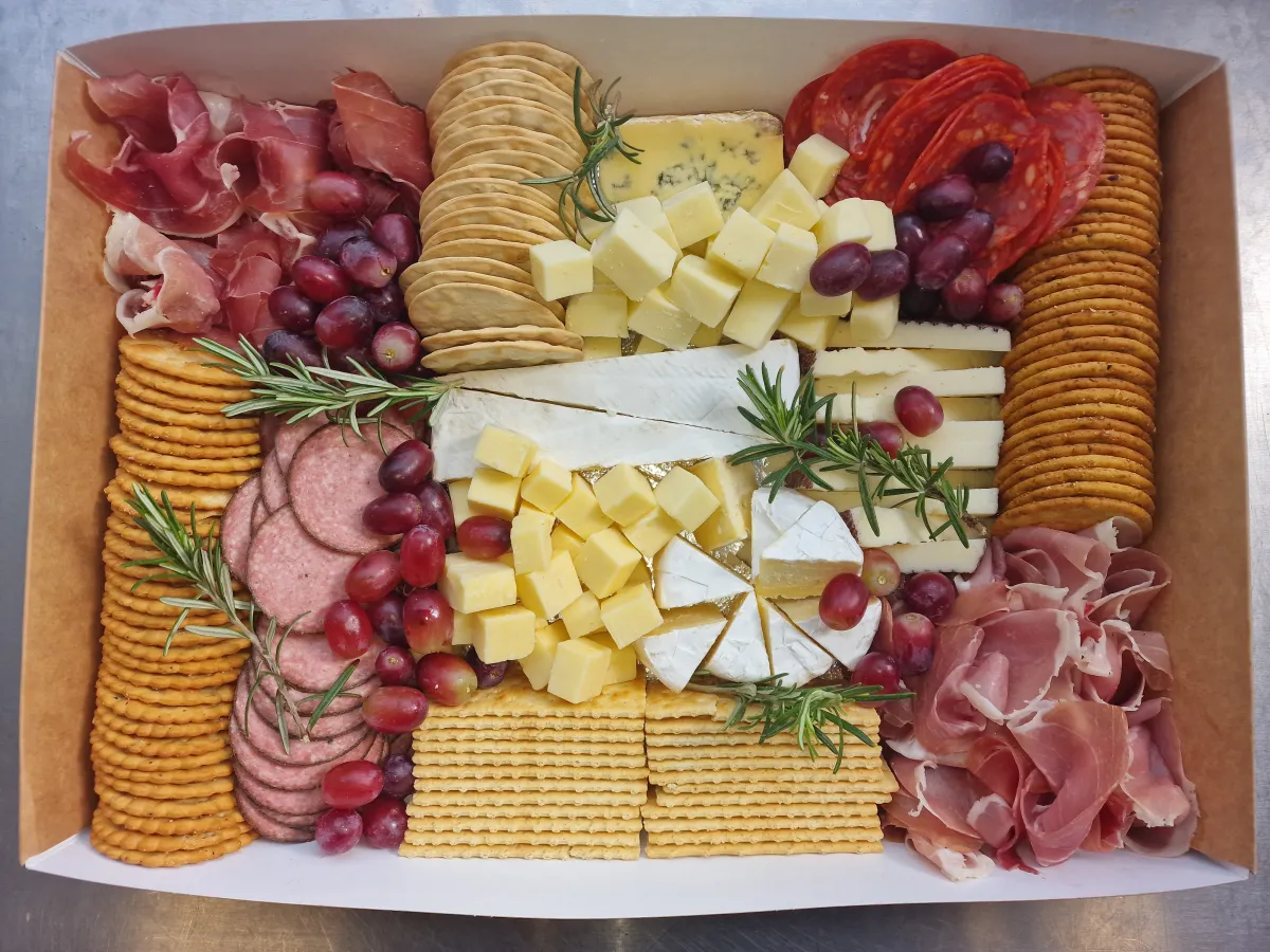 Charcuterie box with prosciutto, salami, brie, crackers and grapes