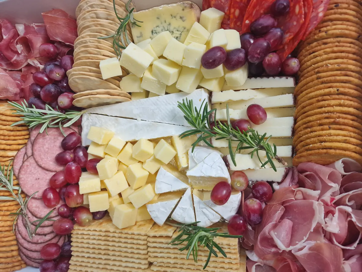 Close-up of cheese board with brie, cheddar, blue cheese and grapes