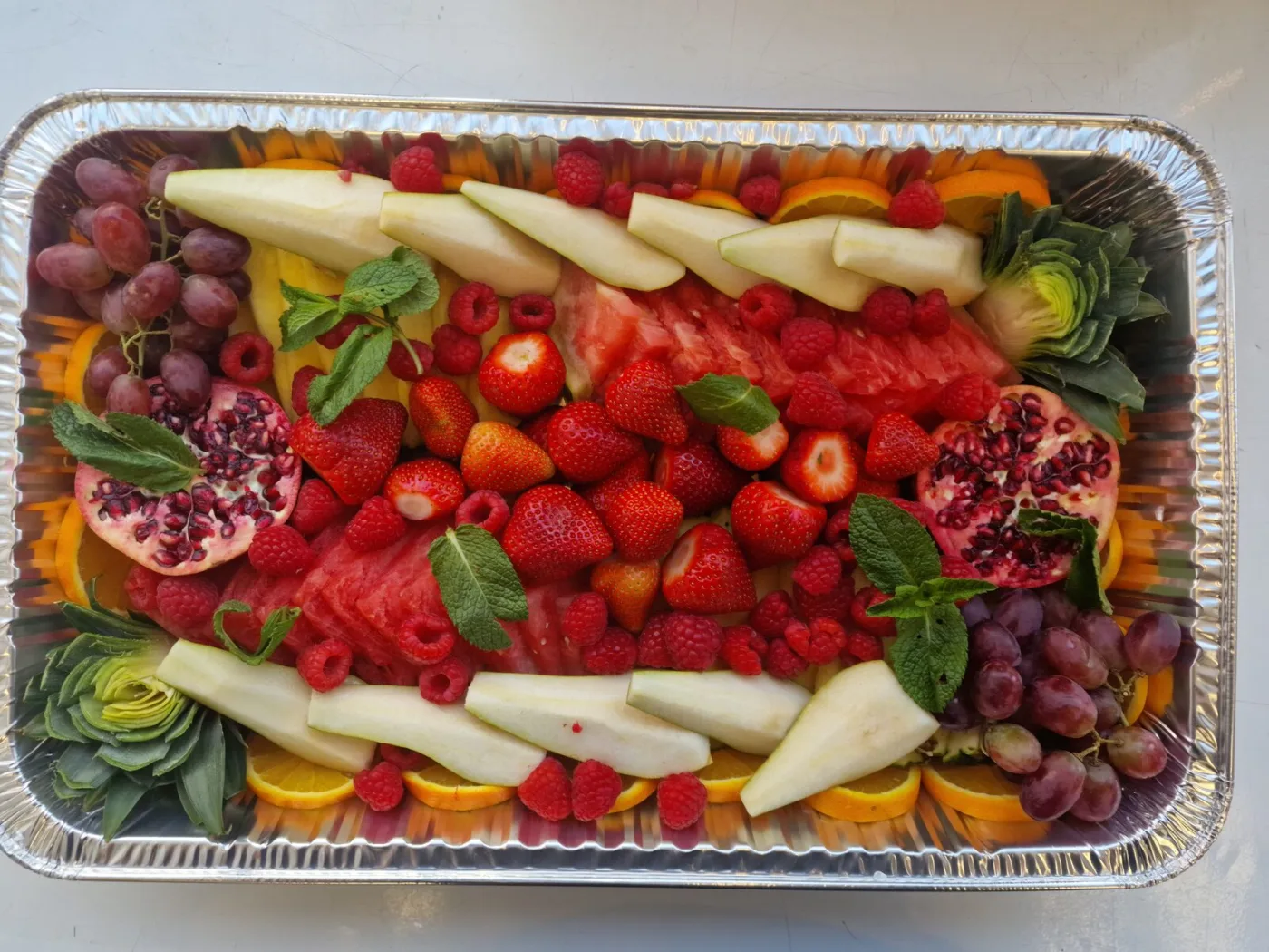 Vibrant fruit platter with strawberries, raspberries, watermelon and pomegranate
